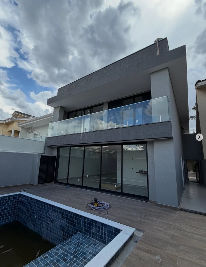 Residência moderna com portas de vidro amplas ao entardecer.